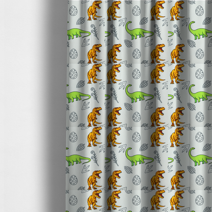 The fabric used to create these made-to-measure curtains is a repeating pattern on a light grey-blue background featuring orange Tyrannosaurus rex dinosaurs, a bright green long-necked sauropod, speckled dinosaur eggs, pinecones, footprints, and leafy sprigs.