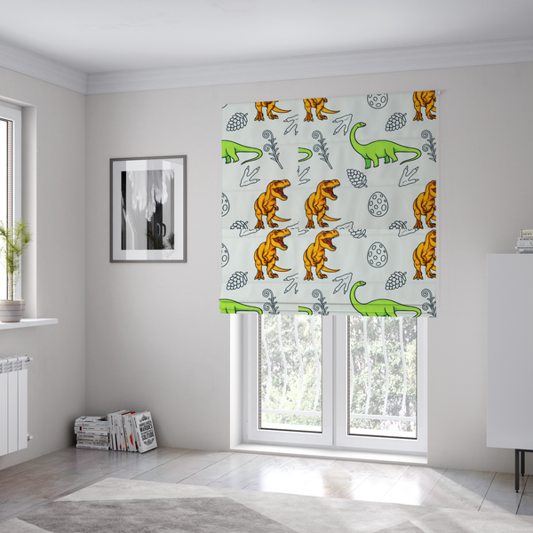 The fabric used to create these Roman blinds is a repeating pattern on a light grey-blue background featuring orange Tyrannosaurus rex dinosaurs, a bright green long-necked sauropod, speckled dinosaur eggs, pinecones, footprints, and leafy sprigs.