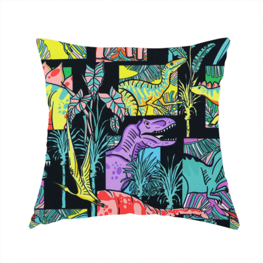 The fabric used to create this handmade cushion is a bold repeating pattern on a black background featuring colourful dinosaurs, including pink, yellow, teal, and purple species, framed within geometric panels and surrounded by tropical foliage.