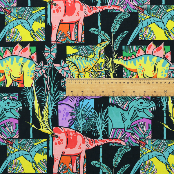 A bold repeating pattern on a black background featuring colourful dinosaurs, including pink, yellow, teal, and purple species, framed within geometric panels and surrounded by tropical foliage.