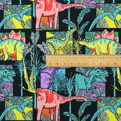 A bold repeating pattern on a black background featuring colourful dinosaurs, including pink, yellow, teal, and purple species, framed within geometric panels and surrounded by tropical foliage.