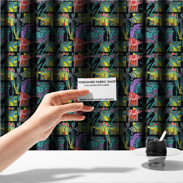 The fabric used to create these made-to-measure curtains is a bold repeating pattern on a black background featuring colourful dinosaurs, including pink, yellow, teal, and purple species, framed within geometric panels and surrounded by tropical foliage.