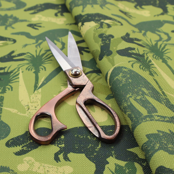 A textured, distressed green and olive camouflage pattern featuring repeating silhouettes of dinosaurs, bones, footprints, and palm fronds.