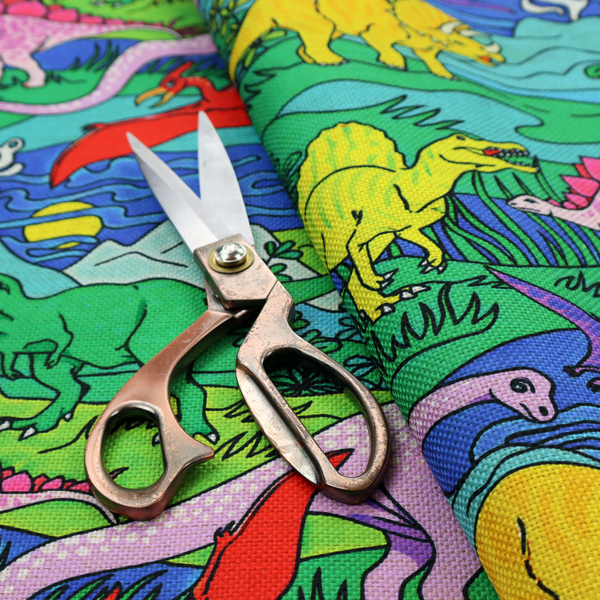 A vibrant, colourful repeating pattern featuring various cartoon dinosaurs including a pink long-neck, yellow triceratops, green T-Rex, and flying pterodactyls amidst a prehistoric landscape.