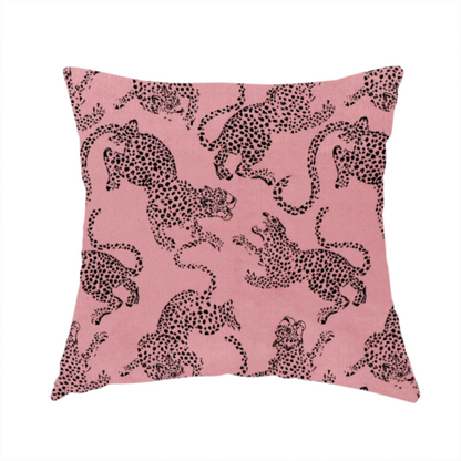 The fabric used to create this handmade cushion is a seamless repeating pattern featuring black stylized leopards or jaguars printed over a muted pink or dusty rose background. The felines are depicted in a dynamic, crouching or leaping pose with detailed spotted markings and long, curving tails.