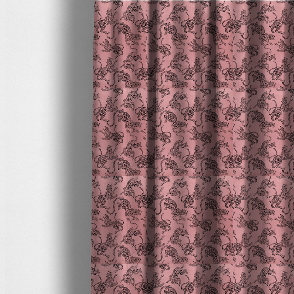 The fabric used to create these made-to-measure curtains is a seamless repeating pattern featuring black stylized leopards or jaguars printed over a muted pink or dusty rose background. The felines are depicted in a dynamic, crouching or leaping pose with detailed spotted markings and long, curving tails.