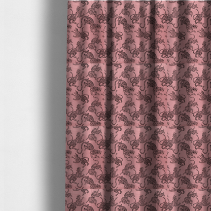 The fabric used to create these made-to-measure curtains is a seamless repeating pattern featuring black stylized leopards or jaguars printed over a muted pink or dusty rose background. The felines are depicted in a dynamic, crouching or leaping pose with detailed spotted markings and long, curving tails.