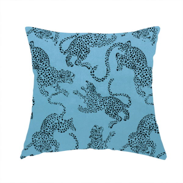 The fabric used to create this handmade cushion is a seamless repeating pattern featuring black stylized leopards or jaguars printed over a vibrant blue background. The felines are depicted in a dynamic, crouching or leaping pose with detailed spotted markings and long, curving tails.