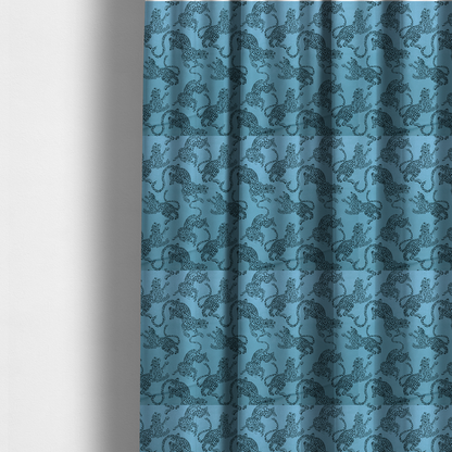 The fabric used to create these made-to-measure curtains is a seamless repeating pattern featuring black stylized leopards or jaguars printed over a vibrant blue background. The felines are depicted in a dynamic, crouching or leaping pose with detailed spotted markings and long, curving tails.