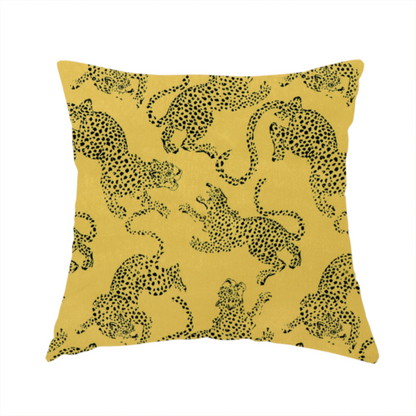 The fabric used to create this handmade cushion is a seamless repeating pattern featuring black stylized leopards or jaguars printed over a mustard yellow or gold background. The felines are depicted in a dynamic, crouching or leaping pose with detailed spotted markings and long, curving tails.