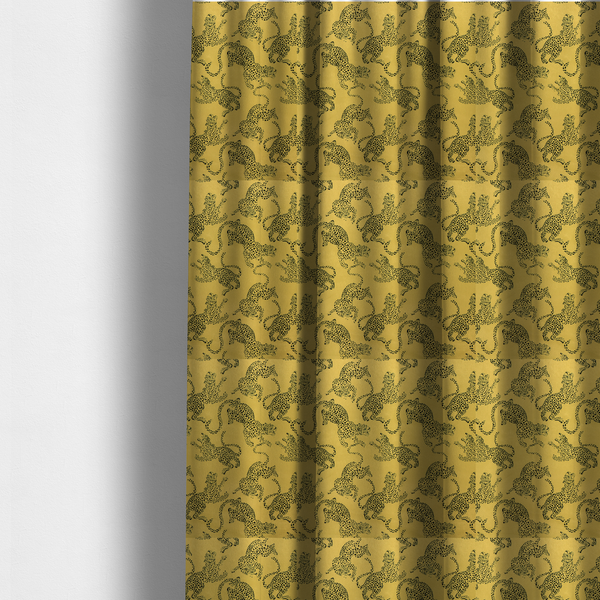 The fabric used to create these made-to-measure curtains is a seamless repeating pattern featuring black stylized leopards or jaguars printed over a mustard yellow or gold background. The felines are depicted in a dynamic, crouching or leaping pose with detailed spotted markings and long, curving tails.