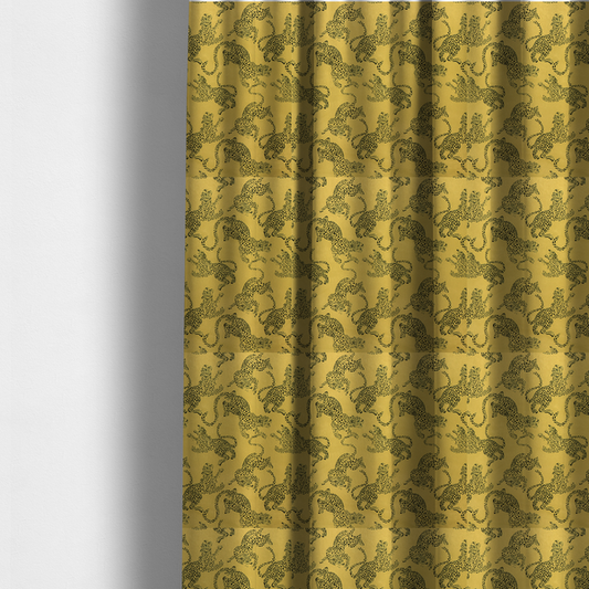 The fabric used to create these made-to-measure curtains is a seamless repeating pattern featuring black stylized leopards or jaguars printed over a mustard yellow or gold background. The felines are depicted in a dynamic, crouching or leaping pose with detailed spotted markings and long, curving tails.