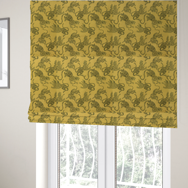 The fabric used to create these Roman blinds is a seamless repeating pattern featuring black stylized leopards or jaguars printed over a mustard yellow or gold background. The felines are depicted in a dynamic, crouching or leaping pose with detailed spotted markings and long, curving tails.