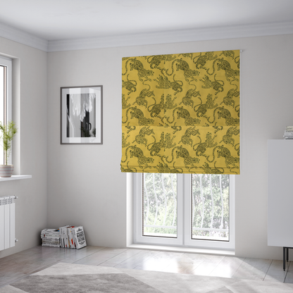 The fabric used to create these Roman blinds is a seamless repeating pattern featuring black stylized leopards or jaguars printed over a mustard yellow or gold background. The felines are depicted in a dynamic, crouching or leaping pose with detailed spotted markings and long, curving tails.