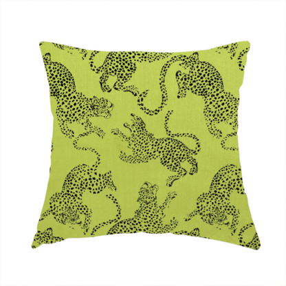 The fabric used to create this handmade cushion is a seamless repeating pattern featuring black stylized leopards or jaguars printed over a vibrant lime green background. The felines are depicted in a dynamic, crouching or leaping pose with detailed spotted markings and long, curving tails.