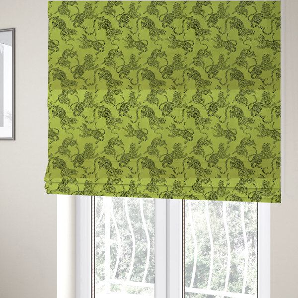 The fabric used to create these Roman blinds is a seamless repeating pattern featuring black stylized leopards or jaguars printed over a vibrant lime green background. The felines are depicted in a dynamic, crouching or leaping pose with detailed spotted markings and long, curving tails.