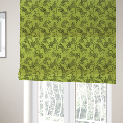 The fabric used to create these Roman blinds is a seamless repeating pattern featuring black stylized leopards or jaguars printed over a vibrant lime green background. The felines are depicted in a dynamic, crouching or leaping pose with detailed spotted markings and long, curving tails.