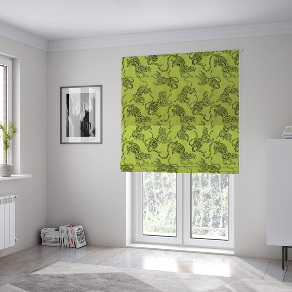The fabric used to create these Roman blinds is a seamless repeating pattern featuring black stylized leopards or jaguars printed over a vibrant lime green background. The felines are depicted in a dynamic, crouching or leaping pose with detailed spotted markings and long, curving tails.
