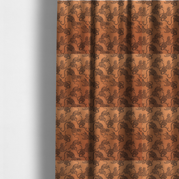The fabric used to create these made-to-measure curtains is a seamless repeating pattern featuring black stylized leopards or jaguars printed over a warm terracotta or burnt orange background. The felines are depicted in a dynamic, crouching or leaping pose with detailed spotted markings and long, curving tails.