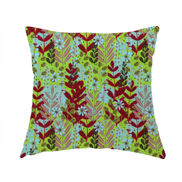 The fabric used to create this handmade cushion is a dense, seamless repeating botanical pattern featuring an array of stylized leaves, foliage, and small blue flowers set against a bright lime green background. The various plant elements are rendered in shades of deep red, mauve, dark brown, and pale blue.