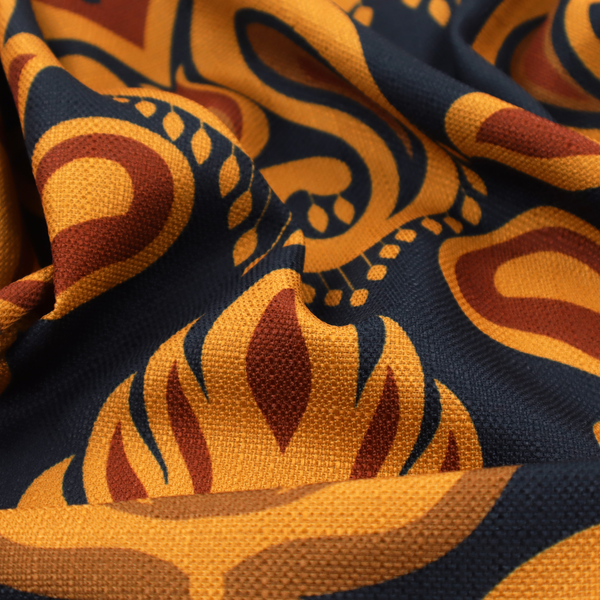 Close-up of a decorative upholstery fabric with a repeating Ikat-style floral motif. The colour palette consists of Mustard Gold, Rust, and Earthy Brown on a Midnight Black woven base, featuring stylized teardrop swirls and geometric petal patterns.