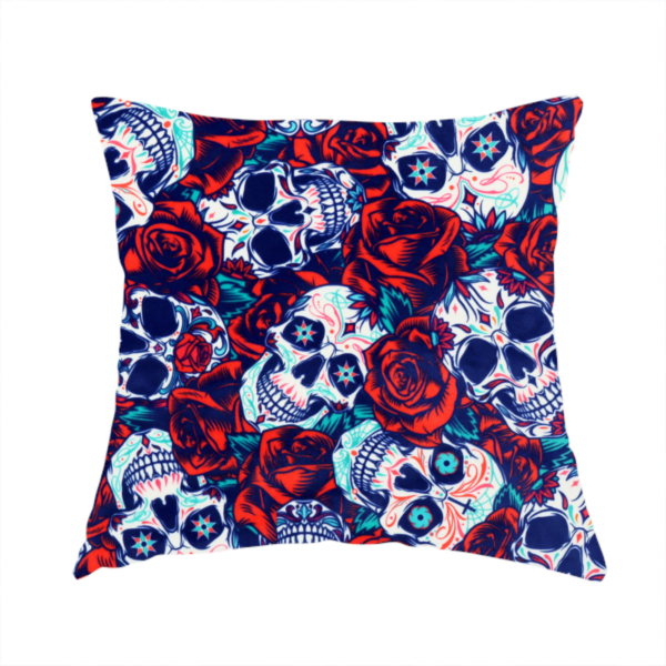 The fabric used to create this handmade cushion is a vibrant repeating pattern on a dark background featuring decorated sugar skulls with intricate blue and red designs, surrounded by deep red roses and green leaves.