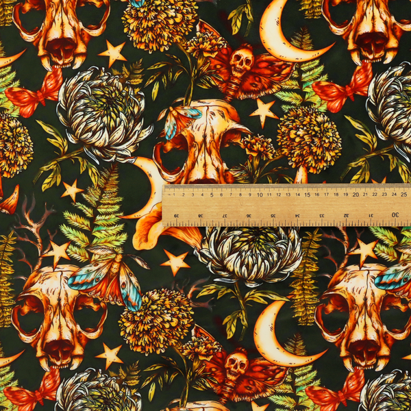A dark and mystical repeating pattern featuring animal skulls, crescent moons, stars, moths, ferns, and chrysanthemums in warm golden and orange tones.