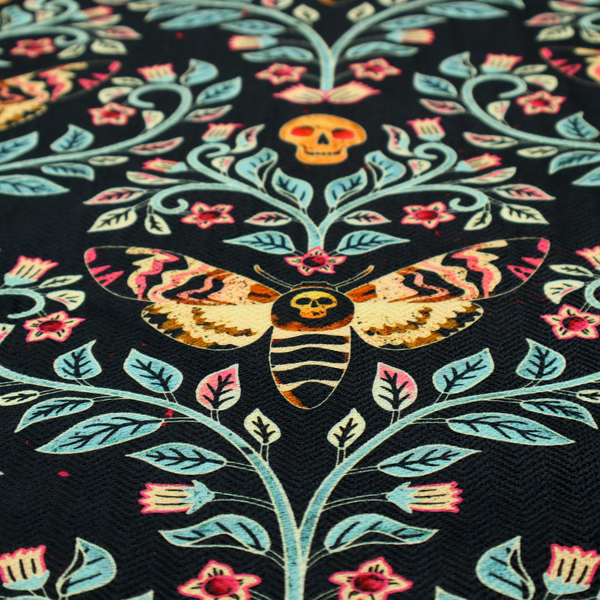 A symmetrical, damask-style repeating pattern on a black background featuring death's-head hawkmoths, human skulls, and ornate scrolling blue-green vines with pink and red flowers.