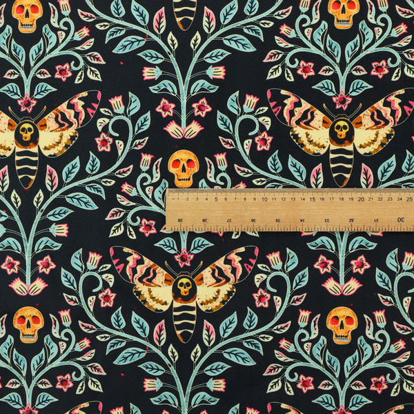 A symmetrical, damask-style repeating pattern on a black background featuring death's-head hawkmoths, human skulls, and ornate scrolling blue-green vines with pink and red flowers.