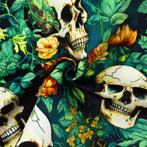 A detailed repeating pattern on a dark background featuring ivory human skulls entwined with vibrant green leafy vines and blooming yellow and orange flowers.