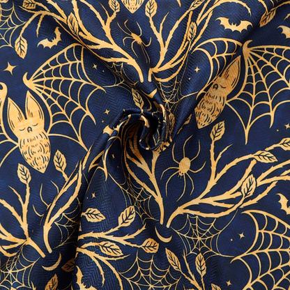 A dark navy blue gothic damask pattern featuring golden yellow bats with webbed wings, intricate spiderwebs, spiders, and twisting branches with leaves.