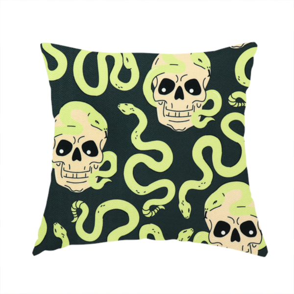 The fabric used to create this handmade cushion is a dark charcoal pattern featuring glowing light green snakes slithering around and coiling through off-white human skulls.