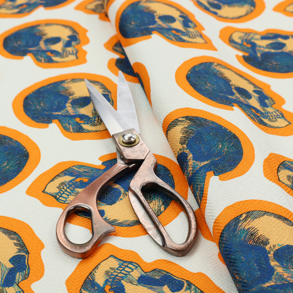 A repeating pattern on an off-white background featuring distressed blue and yellow human skulls outlined in bright orange.