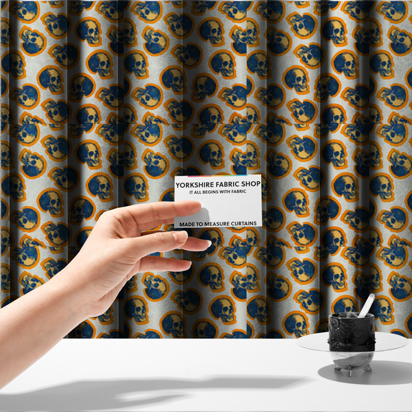 The fabric used to create these made-to-measure curtains is a repeating pattern on an off-white background featuring distressed blue and yellow human skulls outlined in bright orange.