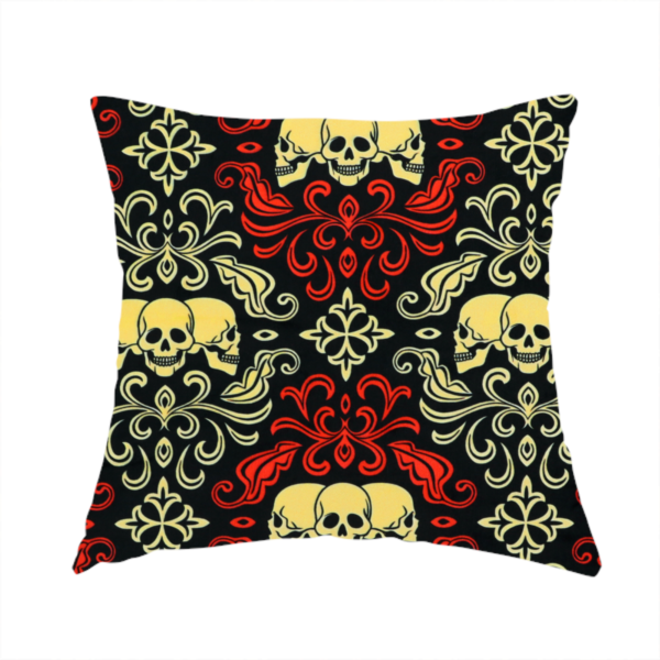 The fabric used to create this handmade cushion is a black gothic damask pattern featuring ornate red and cream scrolling foliage, fleur-de-lis accents, and groups of three yellow human skulls.
