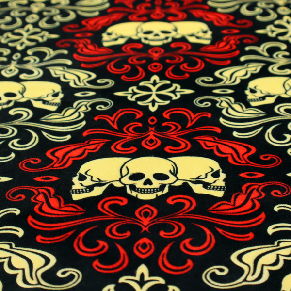 A black gothic damask pattern featuring ornate red and cream scrolling foliage, fleur-de-lis accents, and groups of three yellow human skulls.