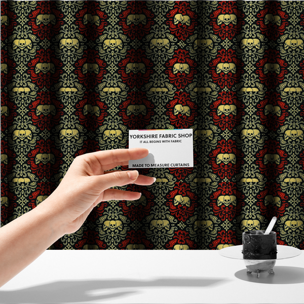 The fabric used to create these made-to-measure curtains is a black gothic damask pattern featuring ornate red and cream scrolling foliage, fleur-de-lis accents, and groups of three yellow human skulls.