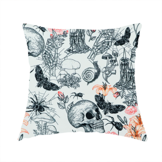 The fabric used to create this handmade cushion is a hand-drawn, sketch-style pattern on an off-white background featuring human skulls, melting candles, spiders, moths, mushrooms, and floral elements like lilies and roses.