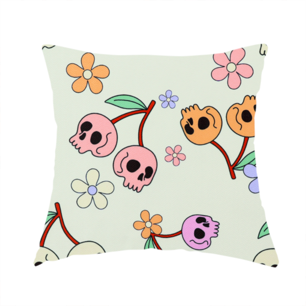 The fabric used to create this handmade cushion is a light retro-style pattern featuring whimsical cherry pairs where the fruit is shaped like colourful skulls in shades of cream, pink, orange, and purple, accented by simple pastel flowers.