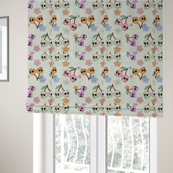 The fabric used to create these Roman blinds is a light retro-style pattern featuring whimsical cherry pairs where the fruit is shaped like colourful skulls in shades of cream, pink, orange, and purple, accented by simple pastel flowers.