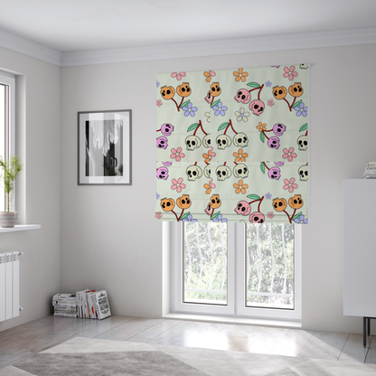 The fabric used to create these Roman blinds is a light retro-style pattern featuring whimsical cherry pairs where the fruit is shaped like colourful skulls in shades of cream, pink, orange, and purple, accented by simple pastel flowers.