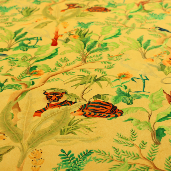 A vibrant yellow fabric featuring a dense tropical jungle pattern with tigers lounging on branches, toucans, herons, monkeys, and lush green foliage.   