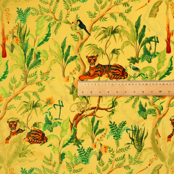 A vibrant yellow fabric featuring a dense tropical jungle pattern with tigers lounging on branches, toucans, herons, monkeys, and lush green foliage.   