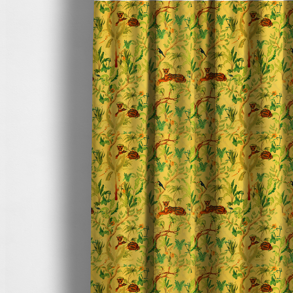 The fabric used to create these made-to-measure curtains is a vibrant yellow fabric featuring a dense tropical jungle pattern with tigers lounging on branches, toucans, herons, monkeys, and lush green foliage.   