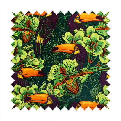 A dark green fabric densely patterned with toucans featuring large orange-and-yellow beaks, surrounded by glowing light green and orange tropical flowers.   