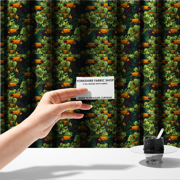 The fabric used to create these made-to-measure curtains is a dark green fabric densely patterned with toucans featuring large orange-and-yellow beaks, surrounded by glowing light green and orange tropical flowers.   