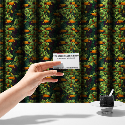 The fabric used to create these made-to-measure curtains is a dark green fabric densely patterned with toucans featuring large orange-and-yellow beaks, surrounded by glowing light green and orange tropical flowers.   