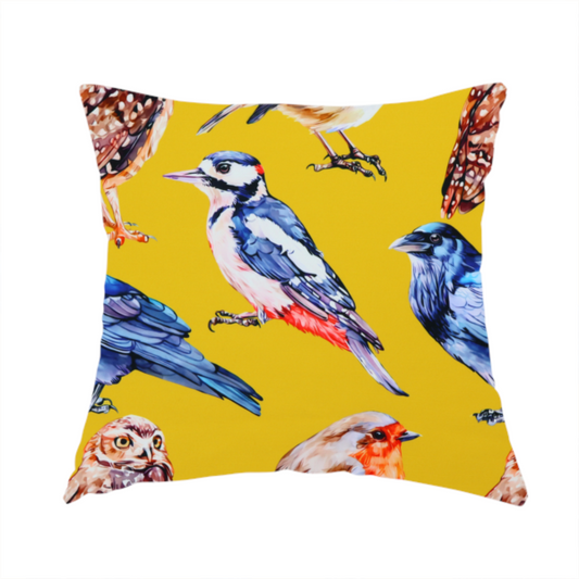 The fabric used to create this handmade cushion is a vibrant yellow fabric patterned with a repeat design of various illustrated birds, including owls, robins, woodpeckers, and bluebirds