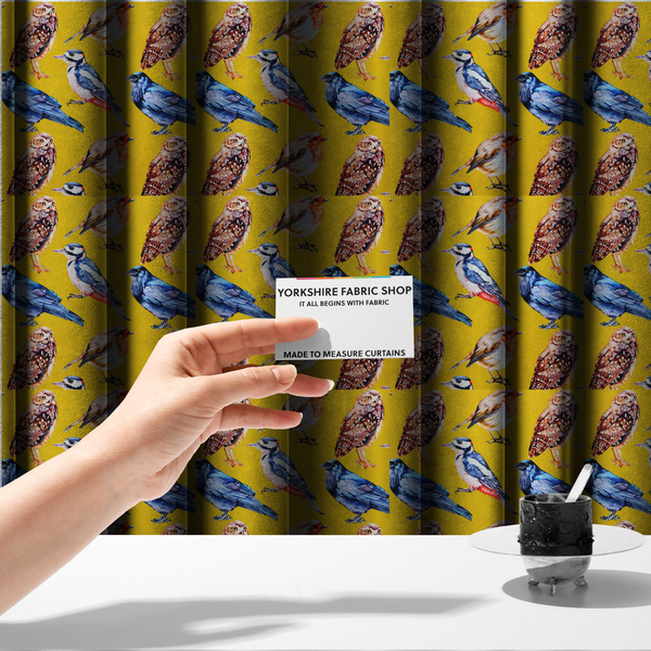 The fabric used to create these made-to-measure curtains is a vibrant yellow fabric patterned with a repeat design of various illustrated birds, including owls, robins, woodpeckers, and bluebirds