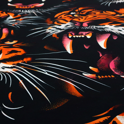 A dark patterned fabric featuring an aggressive, repeated motif of roaring tigers with bared fangs, detailed in vibrant orange, white, and pink against a black background.   